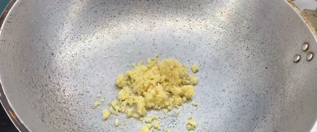 Heat cooking oil in a wok or pan. Add the crushed garlic and cook until light brown and fragrant.