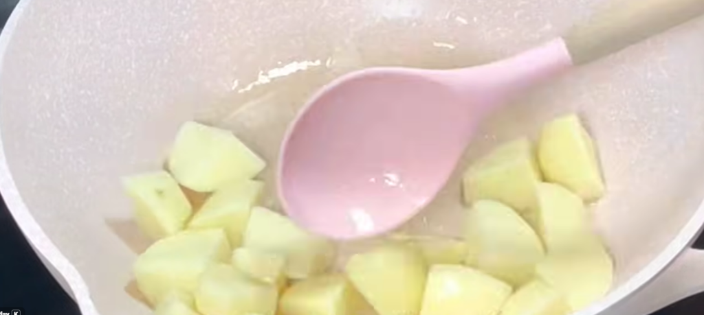 Heat cooking oil in a pan. Fry the potatoes for about 1 minute per side, then remove and set aside. Do the same with the carrots.