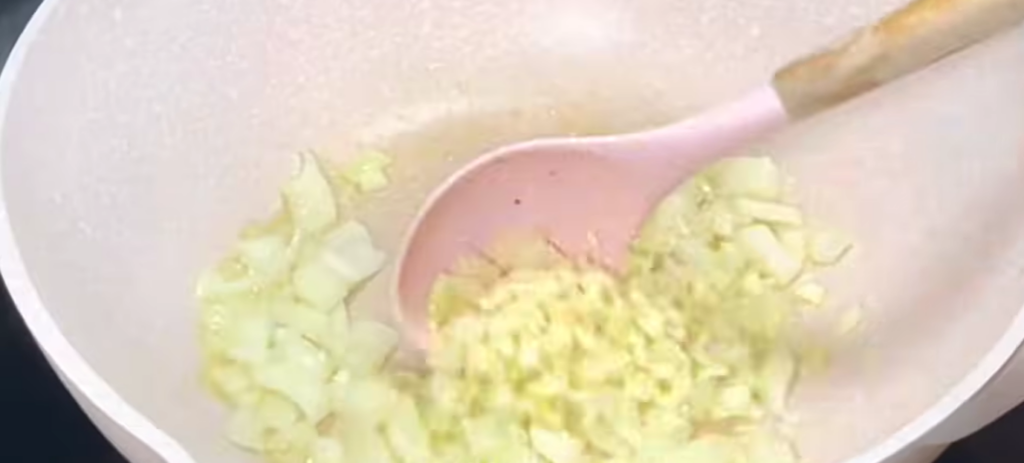 Using the remaining oil, sauté the onion and garlic until fragrant. Add the chopped tomato and cook until softened.