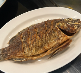 Remove the fried fish from the pan and place it on a serving plate.