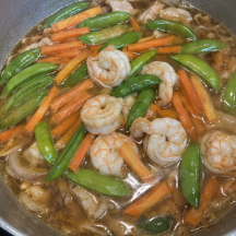 Season with ground black pepper. Add the shrimp, snap peas, and carrots. Cook for about 1 to 2 minutes.