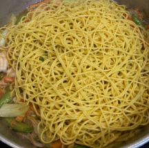 Add the Pancit Bato noodles to the pan. Stir gently so the noodles absorb the broth and sauce evenly.
