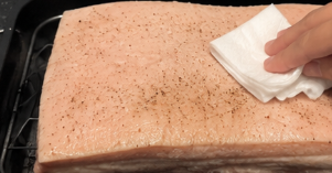 The next day, pat the pork completely dry using paper towels. Place it on a roasting rack inside a roasting pan so hot air can circulate underneath.