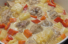 Stir in the evaporated milk, pineapple chunks, and bell peppers. Mix gently.
