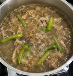 Stir in the tamarind soup mix. Add the sliced long green chilies and season with salt and ground black pepper. Taste and adjust the bile, sourness, salt, and pepper as needed.